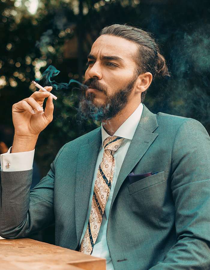 Mann im Anzug raucht eine Zigarette